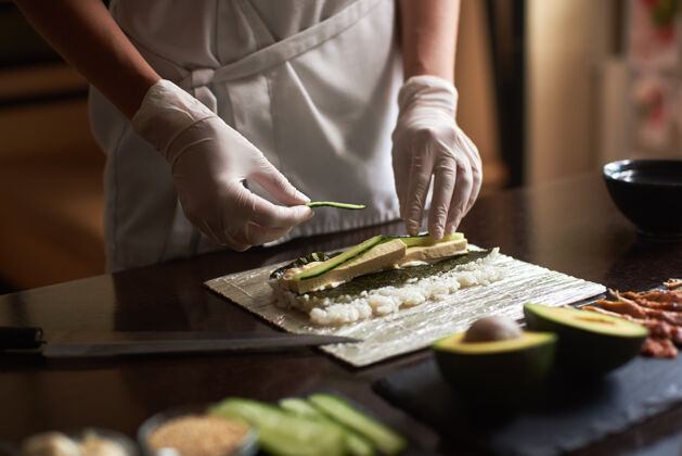 厨房在竹席上用诺丽 米饭 黄瓜和煎蛋卷制作滚轴寿司的过程特写镜头餐厅美味日本
