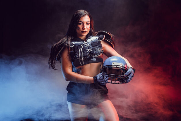 姿势年轻的黑发女郎穿着性感的橄榄球运动员制服摆姿势性感形状深色