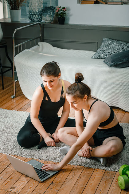 适合女性两位女性朋友在家里聊天 微笑和运动腿部训练运动装