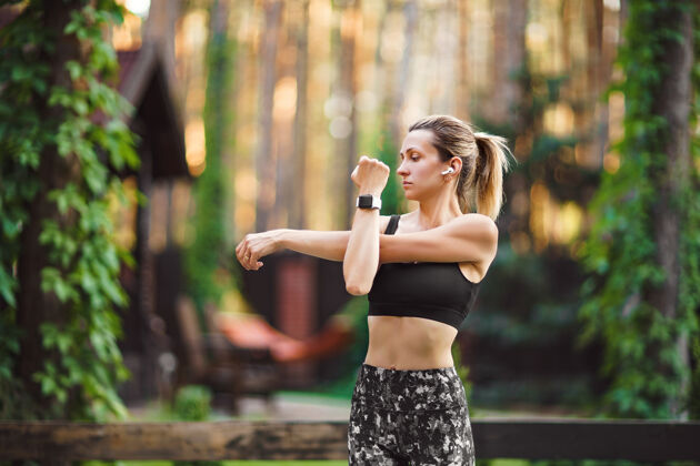 阳光在后院练习晨练瑜伽和伸展的女人健康的生活方式运动装健康运动