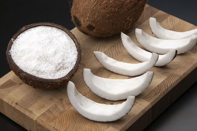 异国情调椰子片加天然牛奶和椰子放在木板上维生素水果健康食品厨房一半贝壳