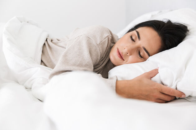 沙发30多岁的中年妇女睡觉的照片 而躺在床上的白色亚麻布在家里亚麻布快乐居住