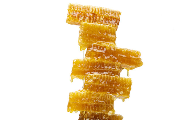糖一滴滴新鲜的蜂蜜从蜡蜜金字塔里滴下来甜点液体味道