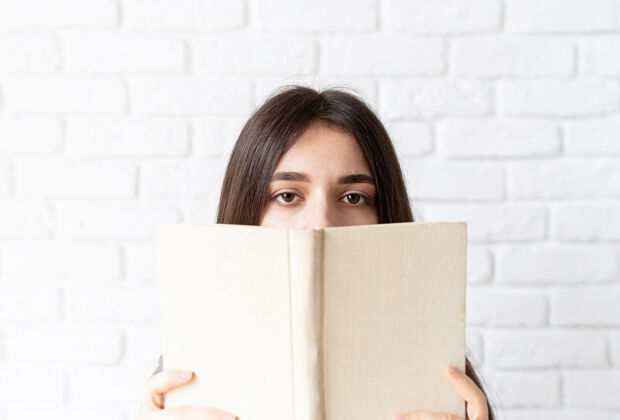 空白一个女人拿着一本打开的书在她面前的特写镜头生活方式开放颜色