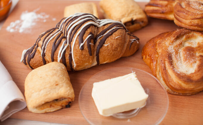 棕色羊角面包和各种烘焙产品在面包店新鲜的烘焙产品早餐烘焙砧板