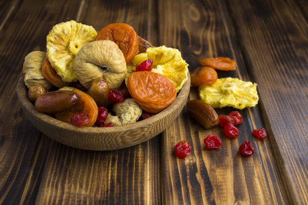 素食者特写不同的干果在棕色蝴蝶结的木桌上位置枣干果