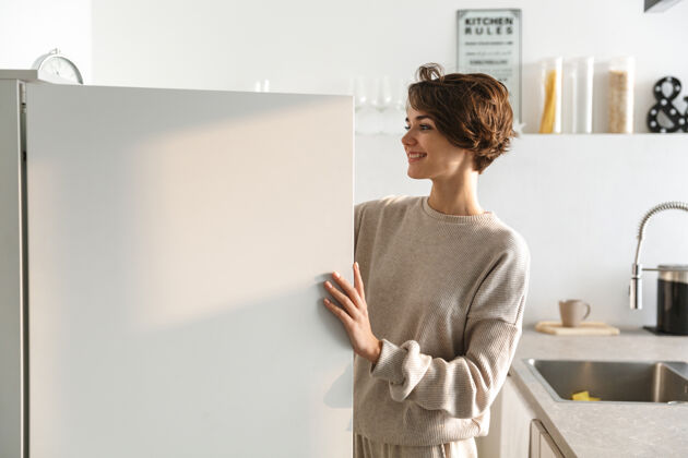 积极快乐的年轻女子站在打开的冰箱前冰箱快乐快乐