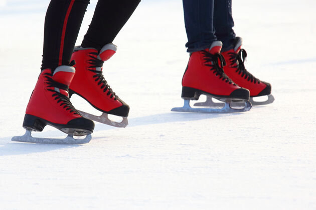 爱好溜冰场上穿着溜冰鞋的女人的腿冻结乐趣娱乐