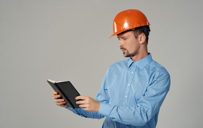 建筑工人土木工程师戴着橙色的安全帽 手里拿着文件 手里拿着记事本工作成功承包商工作