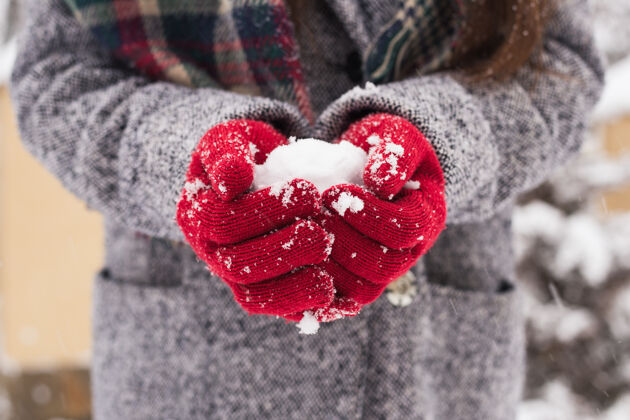 肖像戴着红色手套的女孩捧着雪 祝你圣诞快乐明亮生动手