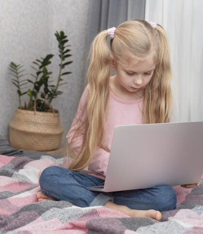 女孩金发女孩在家上网学习 床上放着笔记本电脑设备课程家庭作业