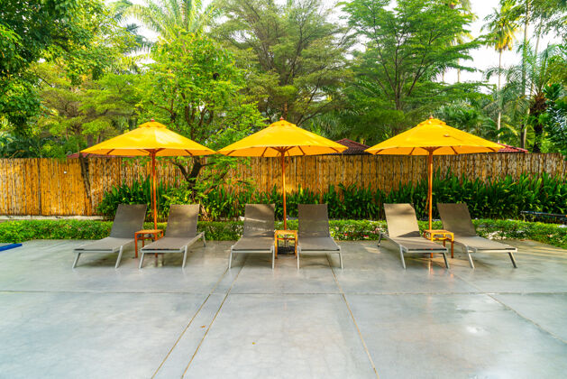 海洋酒店度假村游泳池周围的雨伞和泳池床装饰休闲酒店椰子