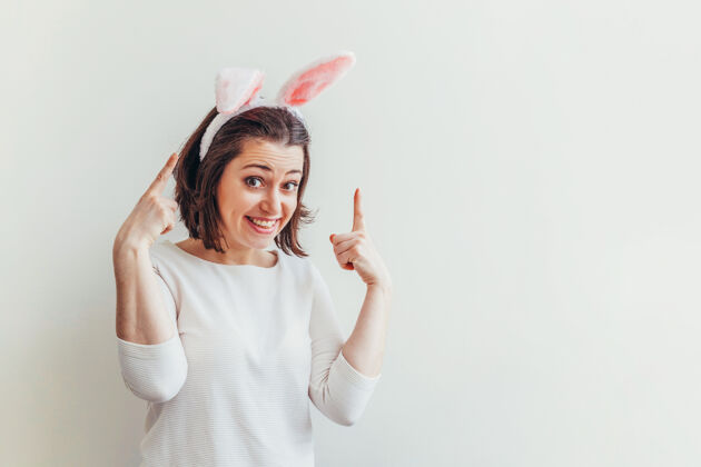 笑戴着兔子耳朵的年轻女子被隔离在白色上女人节日兔子