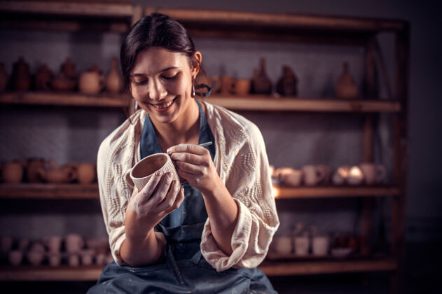 工匠漂亮的手工艺人在陶工的手上塑一个陶瓶手轮工作人类壶手