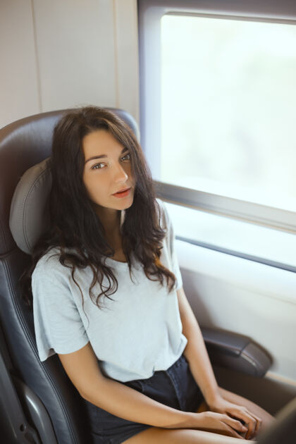 高加索坐在公园里旅游的年轻女游客火车漂亮快乐混血亚裔白人自然生活方式旅行者