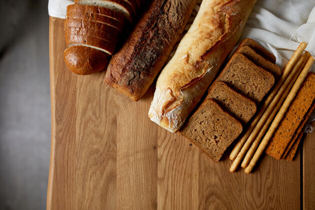 健康木制表面上各种面包的俯视图面包餐桌烘焙