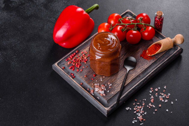 辣椒格鲁吉亚菜的辛辣调味料阿吉卡在一个碗里 用红辣椒和大蒜放在混凝土桌上特写镜头自然木材特写