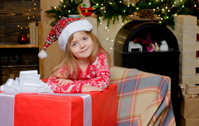 幼儿圣诞快乐 小女孩 圣诞快乐现在漂亮戴圣诞帽的小女孩吹童年快乐