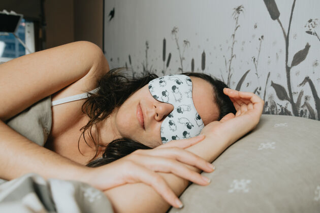 心情一个戴着白色睡眠面罩睡在床上的年轻女人年轻眼睛房子