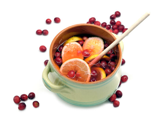 静物用红莓和柠檬制成的不含酒精的饮料 放在一个大的圆形绿色罐子里 里面有木勺饮料锅柳条