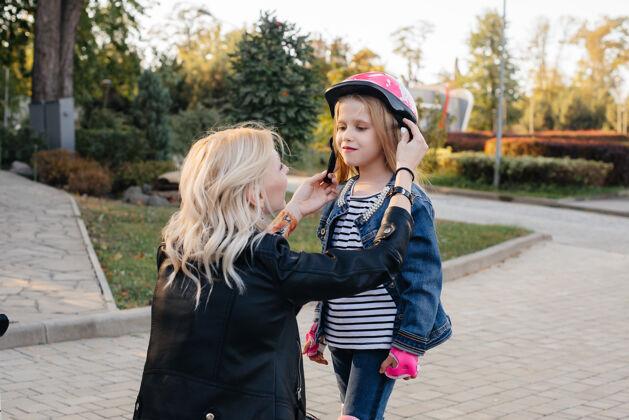活动妈妈帮小女儿打扮好装备和头盔 准备去公园玩赛格威孩子驾驶妈妈