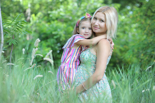 健康快乐的孕妇和她的女儿在夏日公园合影休息美丽怀孕