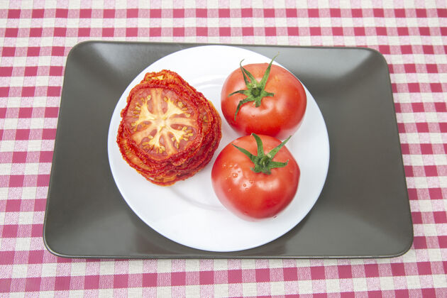 红色新鲜的红番茄和干番茄片放在烤盘上维生素板蔬菜食品健康维生素新鲜