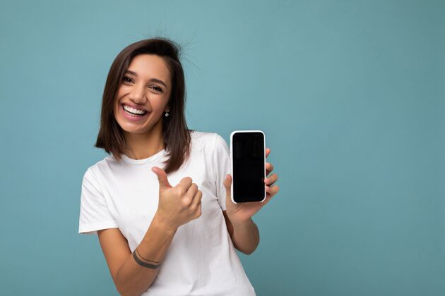 女士迷人的微笑年轻的黑发女子漂亮穿着白色t恤站在蓝色孤立手机联系方式电话