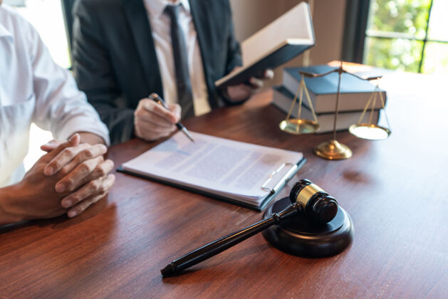房地产男性公证律师或法官咨询或讨论合同文件木槌争议建议