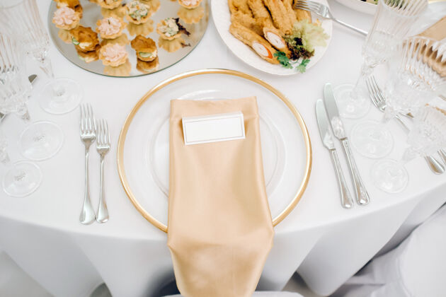 盘子婚宴桌上的盘子 节日餐桌的装饰鲜花庆典银器