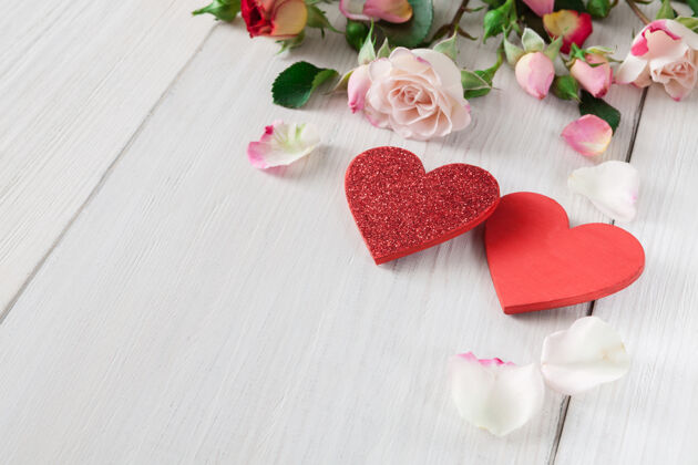 花瓣情人节与粉红色的玫瑰花瓣和手工制作的白色乡村木材木心婚礼墙壁花束