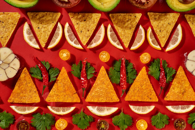 脂肪创意几何食物模式从墨西哥玉米片 新鲜蔬菜 水果 蔬菜 辣椒 大蒜-番茄辣椒酱的配料上的红色背景.平坦躺下开胃菜快餐大蒜