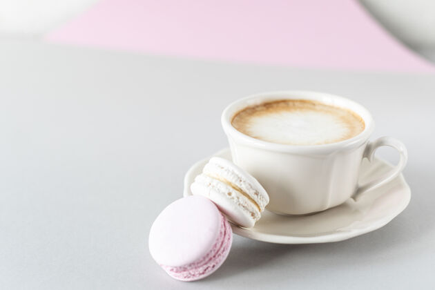 饮料一杯咖啡 面食为蛋糕上的灰色和粉色表面杏仁饼早晨粉彩