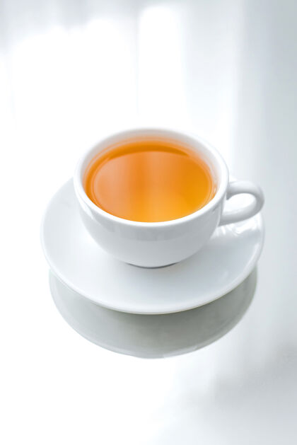 热茶碟上的白瓷杯绿茶草药风味早餐