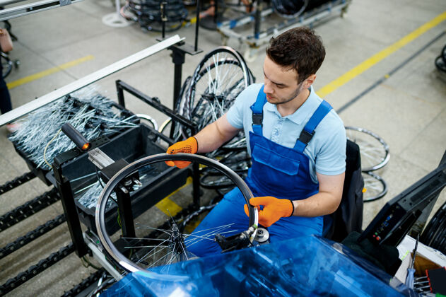 铝工人用机床安装新的自行车辐条工厂自行车车轮在车间装配细节自行车装配