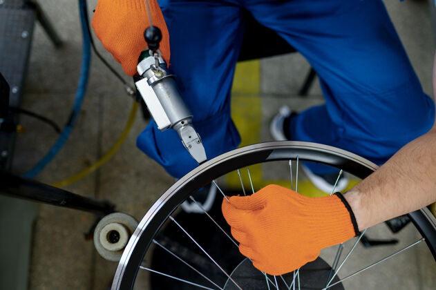 齿轮工人用机床在工厂上安装新的自行车轮辋 顶部视图.自行车车轮装配车间 自行车配件安装工作自行车工业