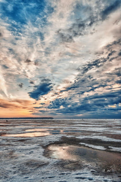 自然日出在冰封的河面上冬日的早晨 在远处渔夫们坐着早晨阳光运动