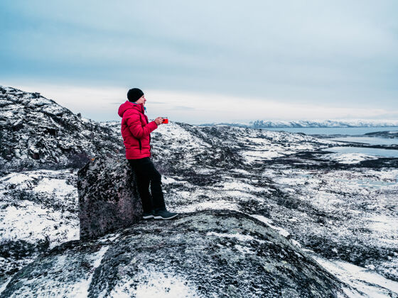 童话一个在山顶一个在极地山顶上的男人手里拿着一杯热茶极限活跃
