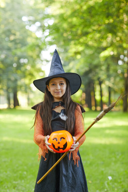 邪恶穿着女巫服装站在公园外的小女孩的画像魔术恐怖巫婆