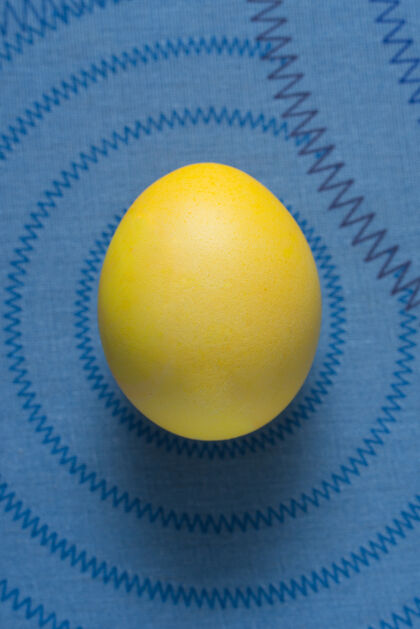 饮食蓝色表面上的黄色复活节彩蛋生禽类配料