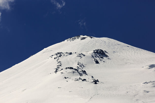冒险厄尔布鲁斯山的东峰被雪覆盖了风景攀岩者寒冷