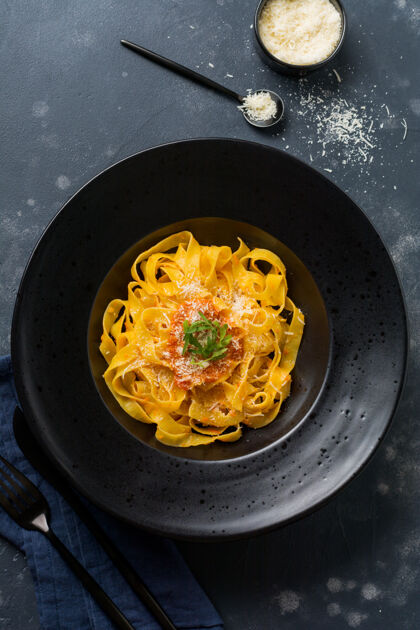 番茄传统意大利帕萨特沙司和帕尔马干酪的意大利面 黑色盘子 深色表面大蒜奶酪绘画