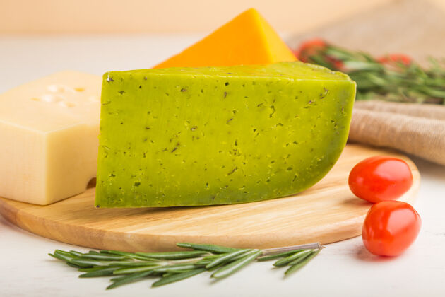 小吃绿色罗勒奶酪和各种奶酪与迷迭香和西红柿在木板上的白色木质表面布里套装烹饪