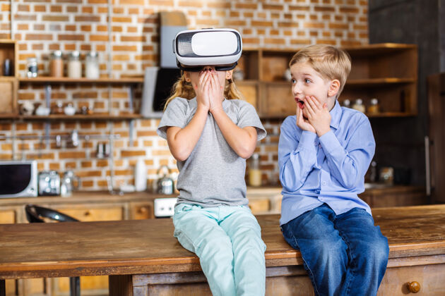 朋友坐在厨房里测试虚拟现实设备的小兄弟姐妹们感到非常惊喜虚拟现实童年虚拟
