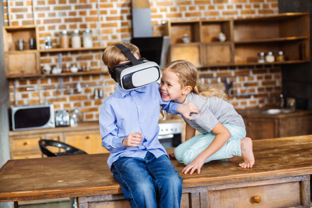 设备积极的小兄弟姐妹在测试虚拟现实设备时玩得很开心未成年童年兄弟姐妹