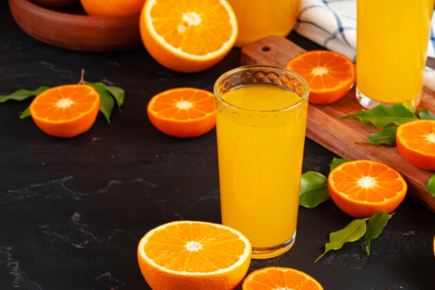 果汁一杯橙汁和切好的橙子放在桌上切割挤压饮食