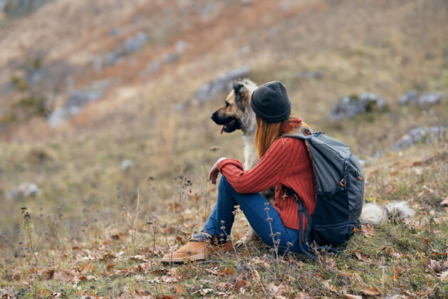 运动女徒步旅行者旁边的一只狗在山上自然度假风景散步森林年轻人