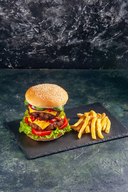 三明治特写镜头的美味三明治和薯条在深色托盘上的黑色表面芝士汉堡射击根蔬菜