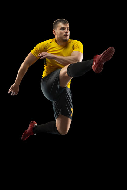 肌肉在黑墙上训练的年轻足球运动员比赛运动球