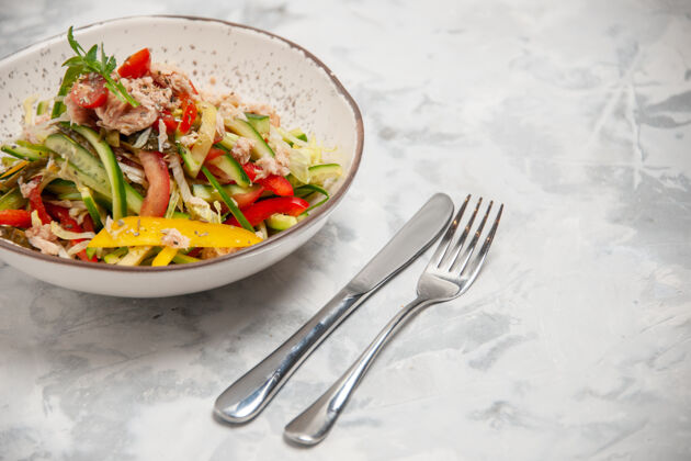 胡椒鸡肉沙拉的前视图 蔬菜和餐具放在染色的白色表面上盘子沙拉色斑